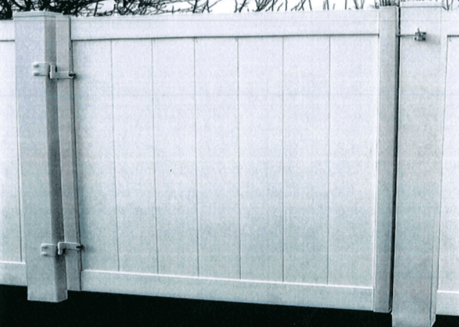White vinyl privacy fence with vertical planks and metal hinges.