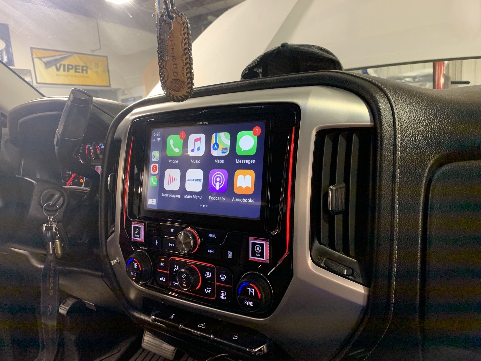 Car dashboard with Apple CarPlay touchscreen and climate controls in a parked vehicle