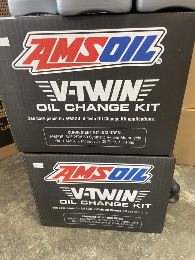 Two stacked AMSOIL V-Twin oil change kit boxes on a black surface