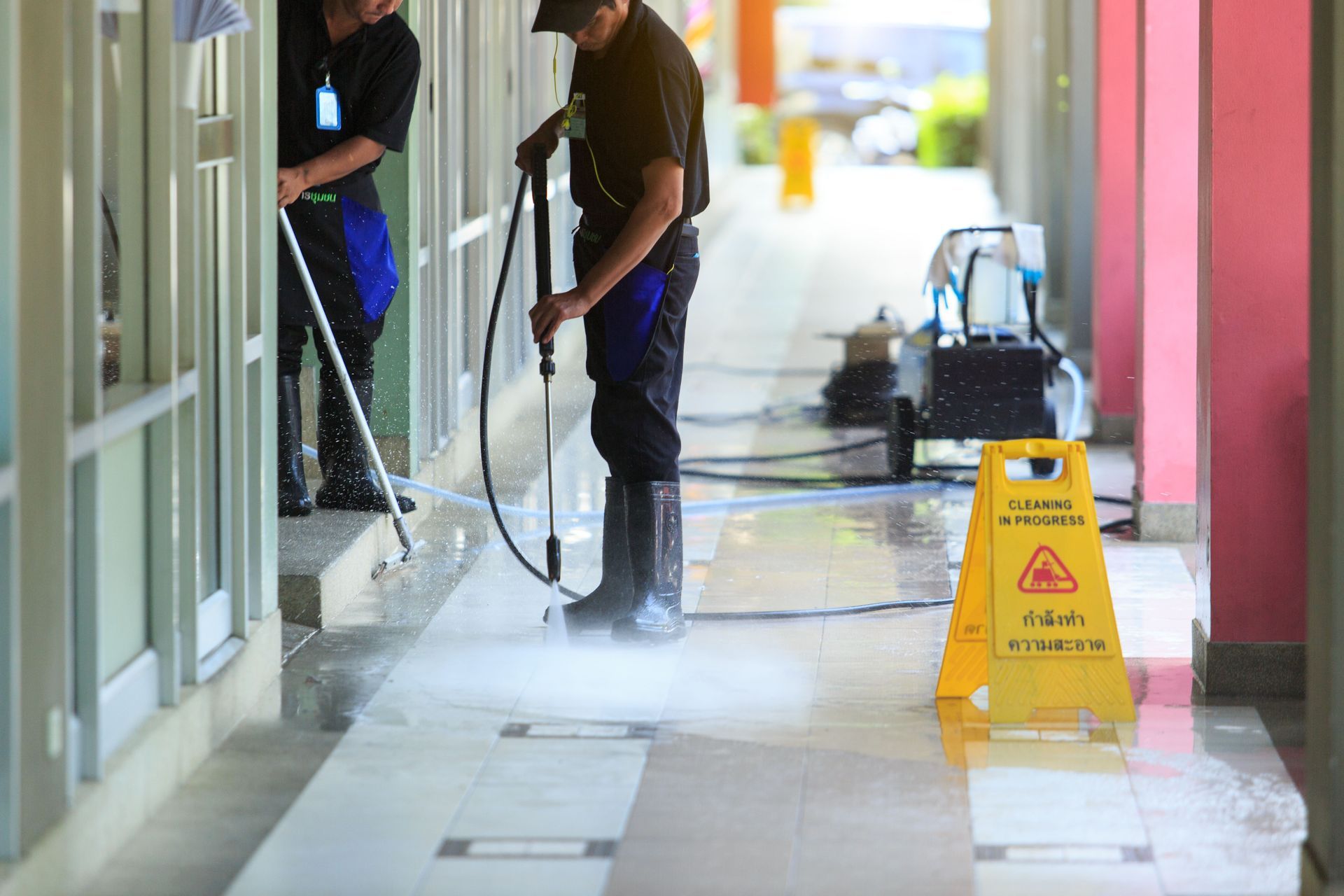a man is cleaning the floor of a building with a high pressure washer