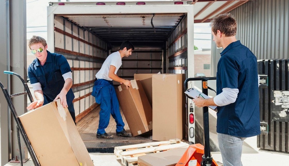 A group of men are loading boxes into a truck.