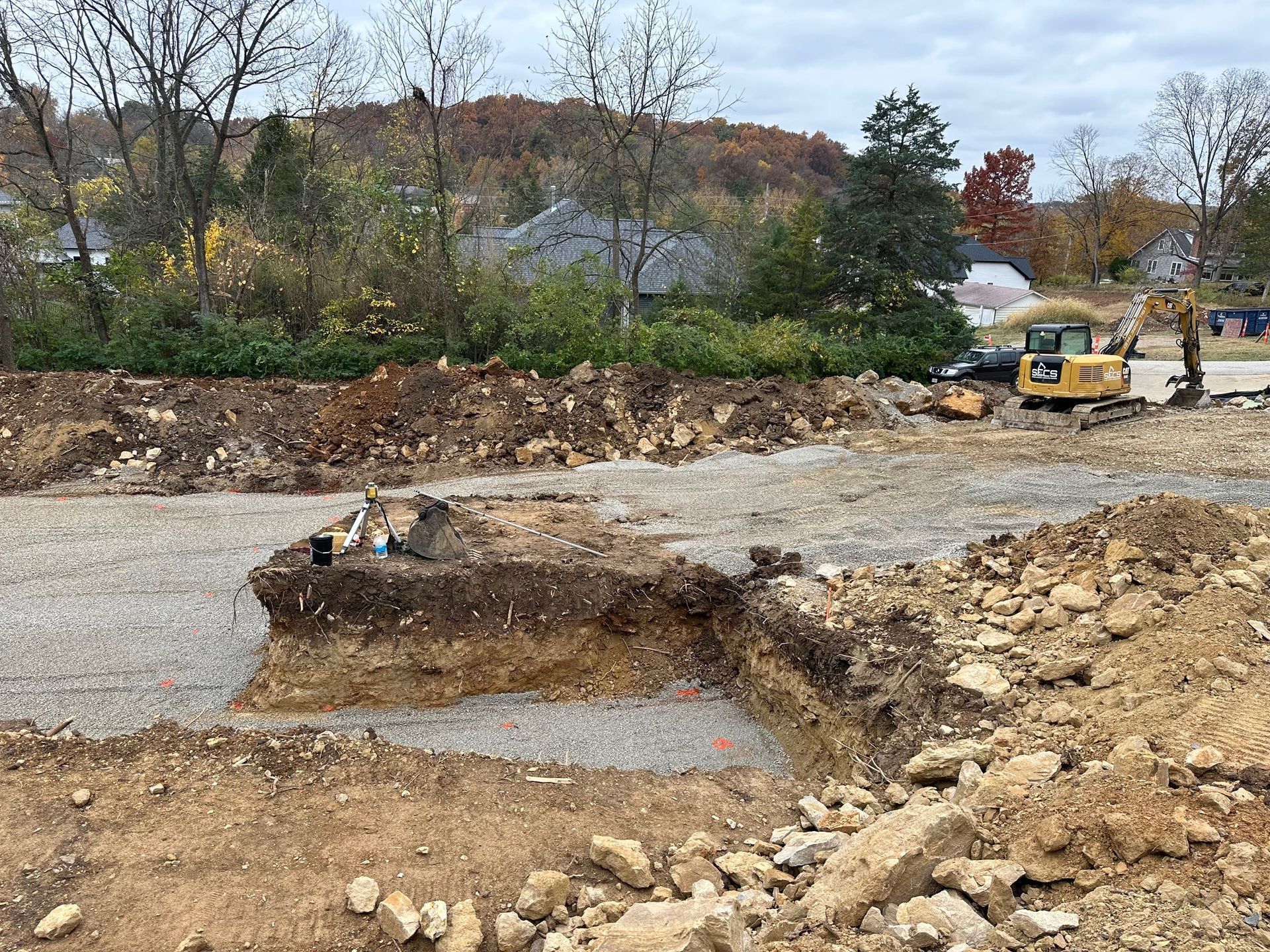 A construction site with a lot of dirt and rocks and a bulldozer in the background.