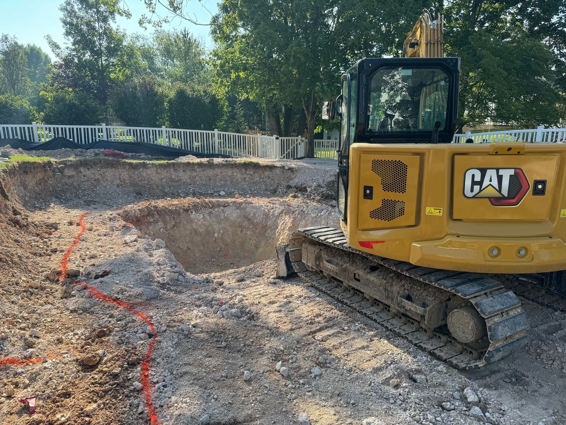 A yellow cat excavator is sitting in a dirt field.