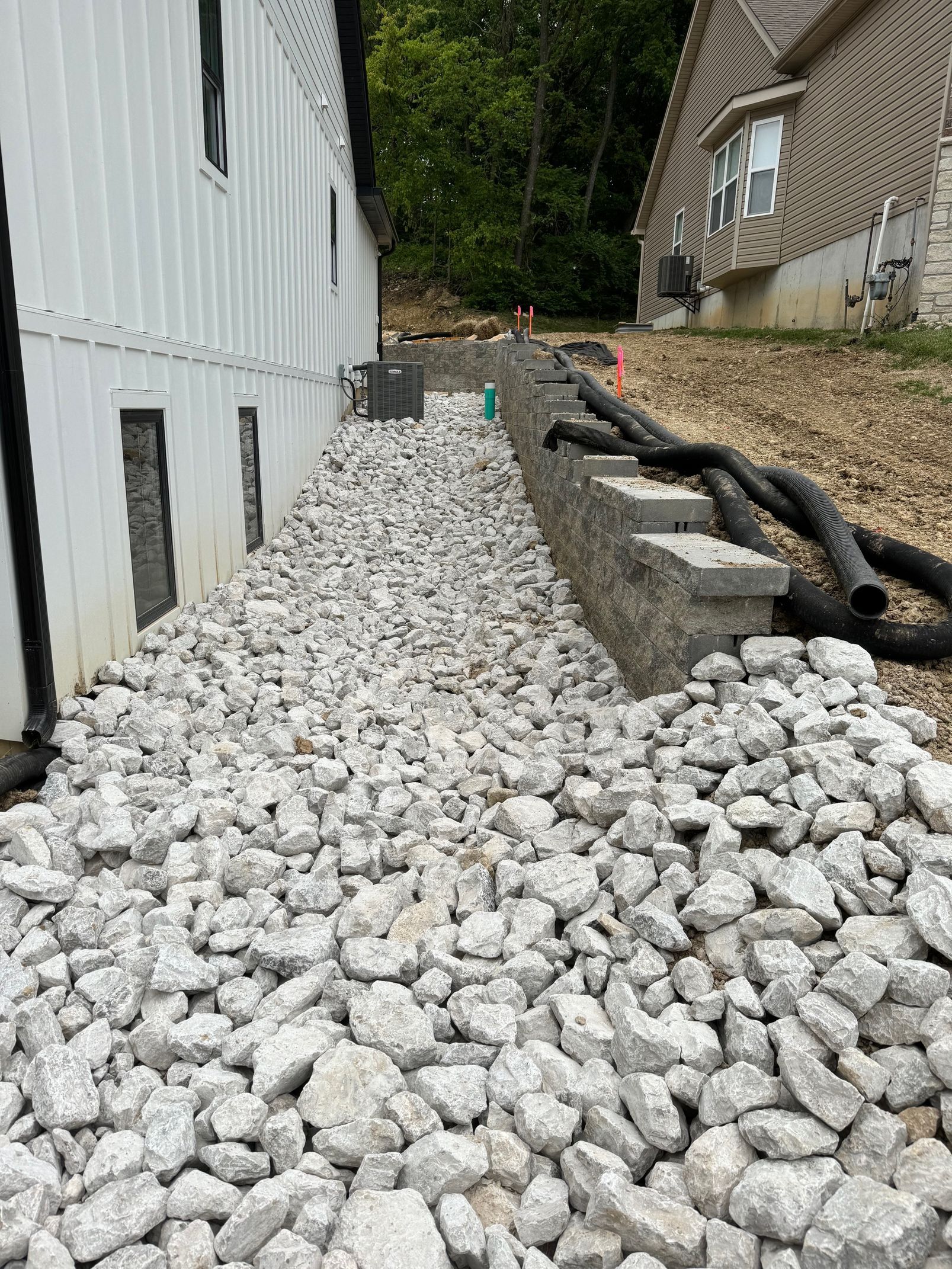 A pile of rocks is sitting in front of a house.