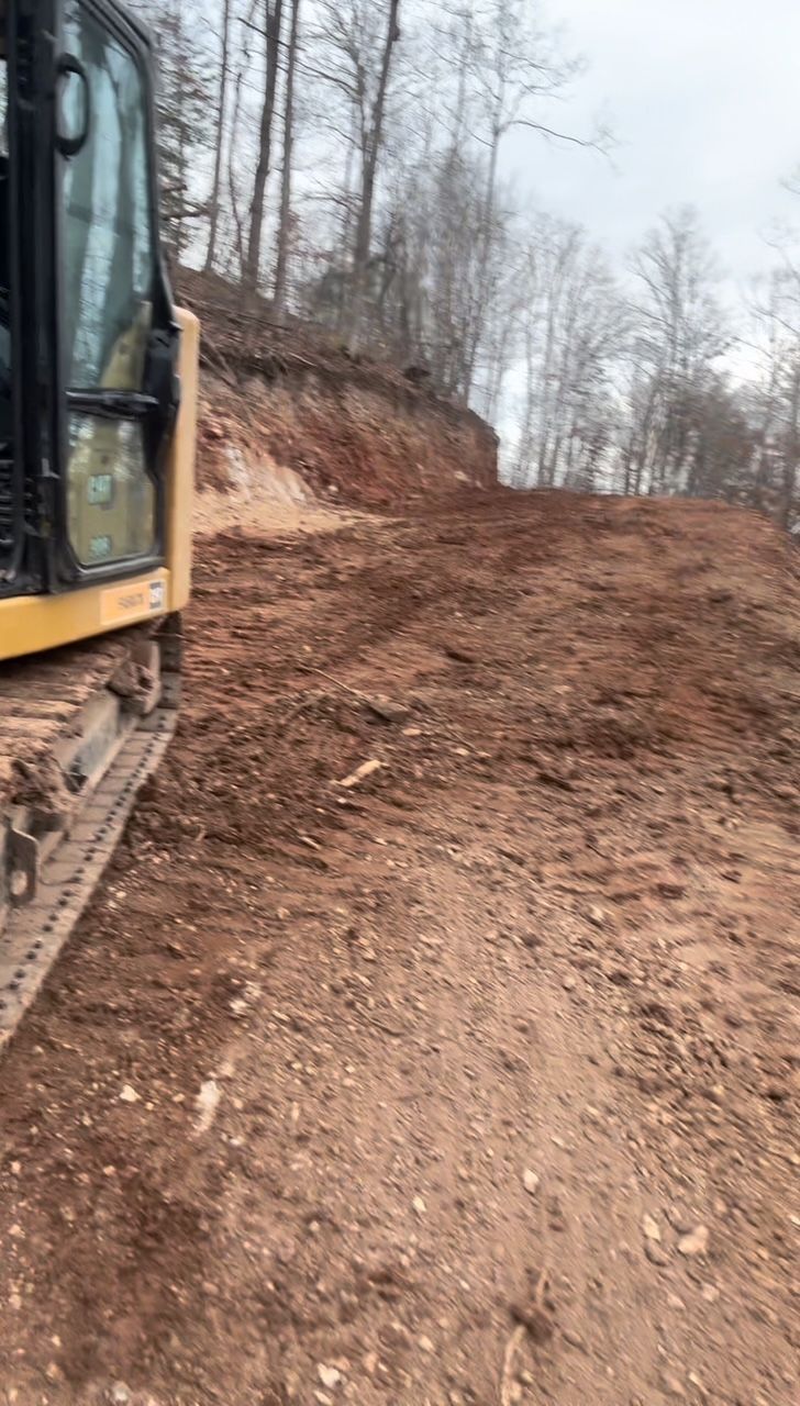 A bulldozer is moving dirt on a dirt road.