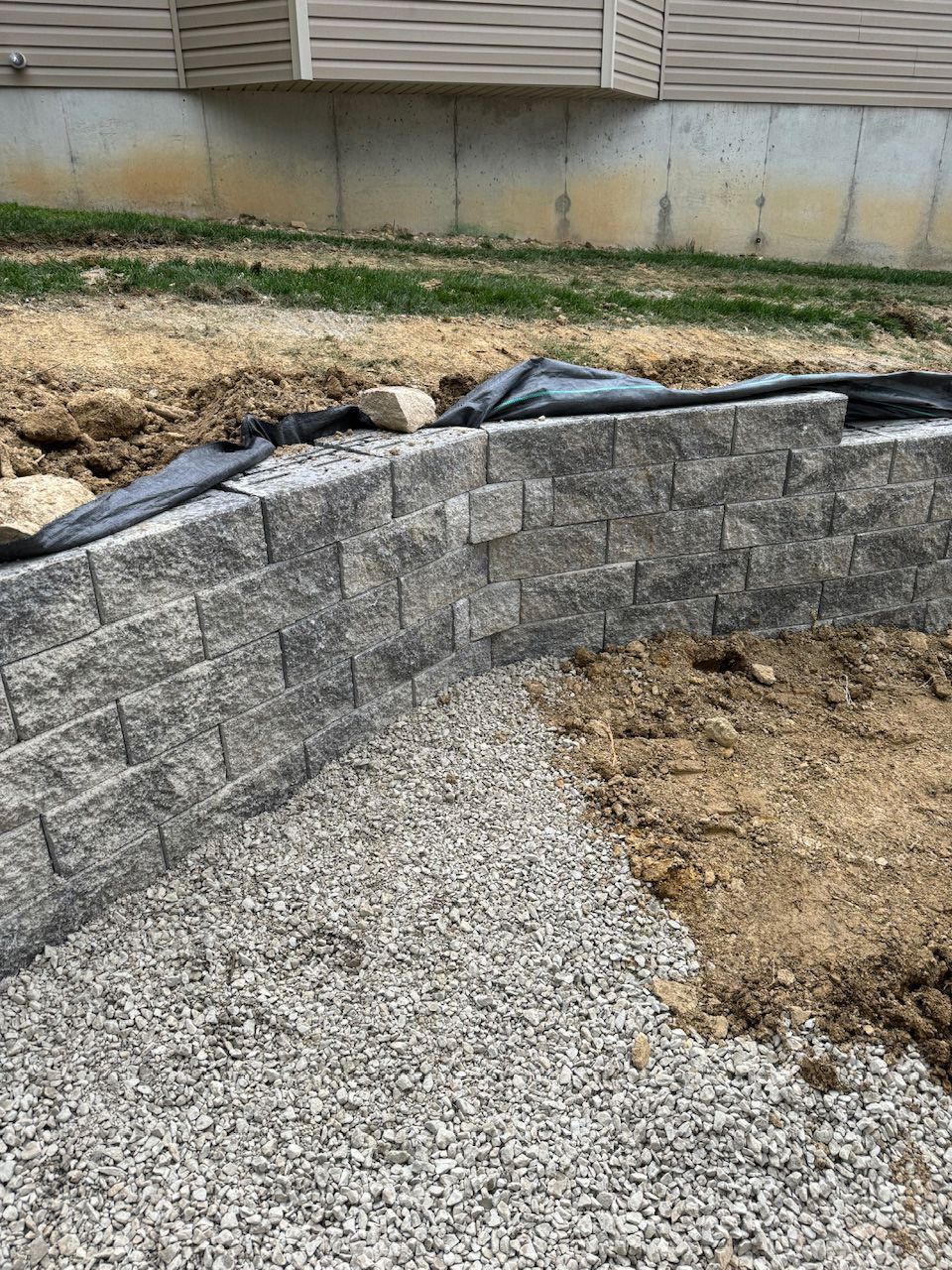 A brick wall is being built in front of a house.