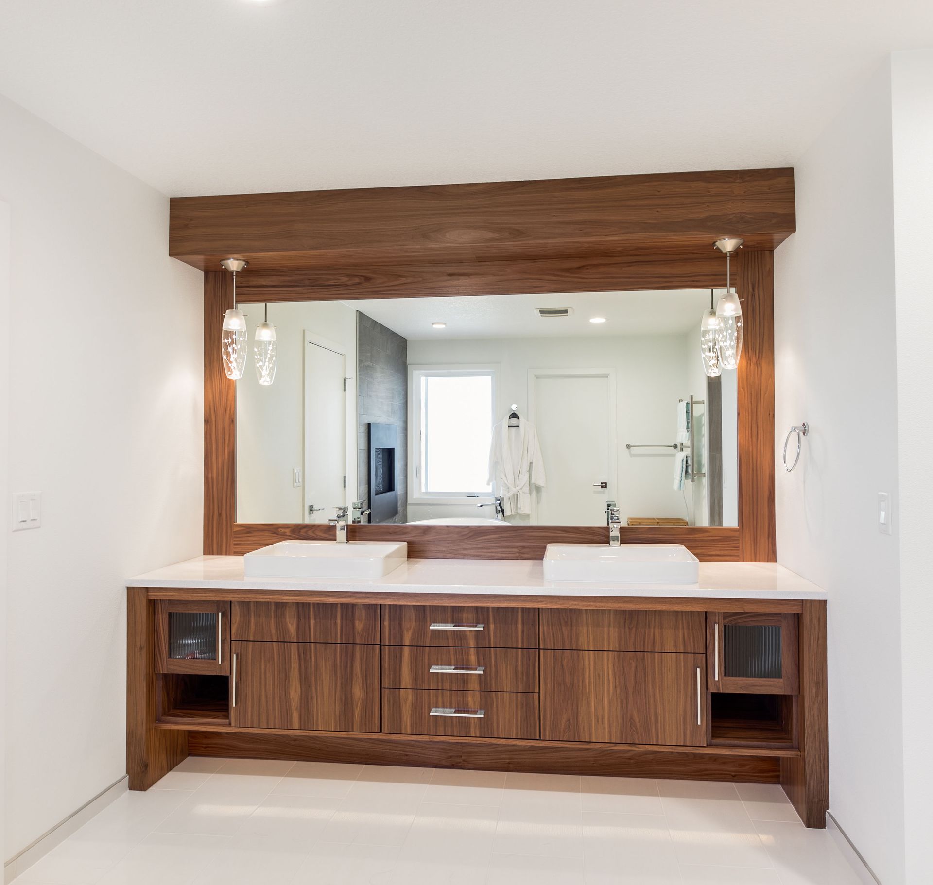 Wooden bathroom vanity with large mirror and double sinks in a bright modern room