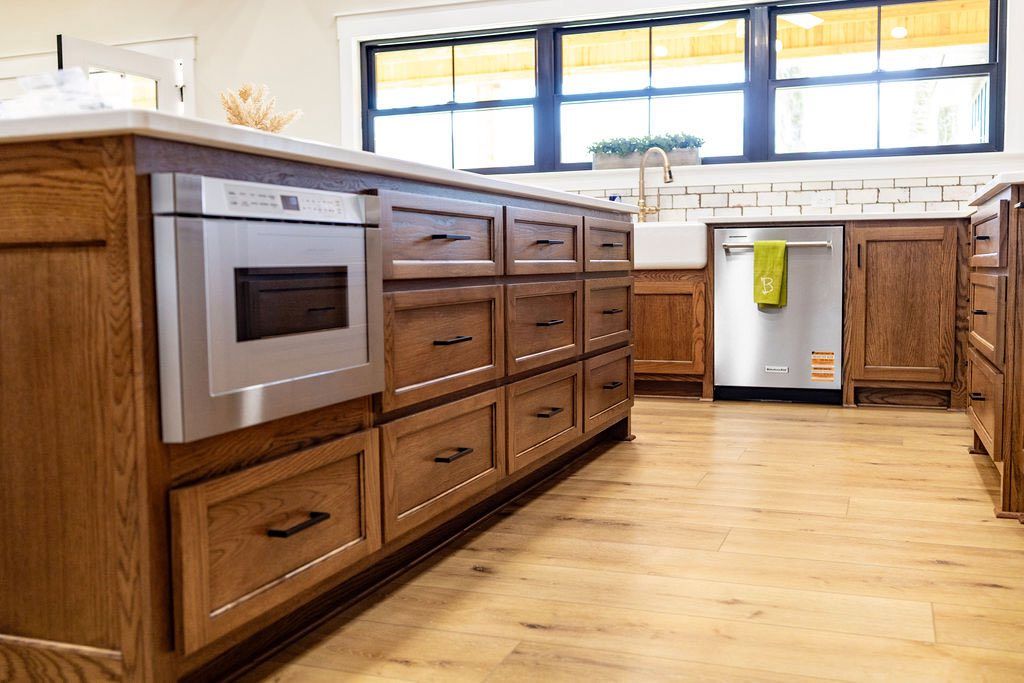 Modern kitchen with wood cabinets, built-in oven, white appliances, and large windows