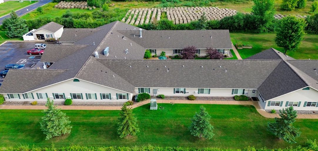 An aerial view of a large house surrounded by trees and grass.
