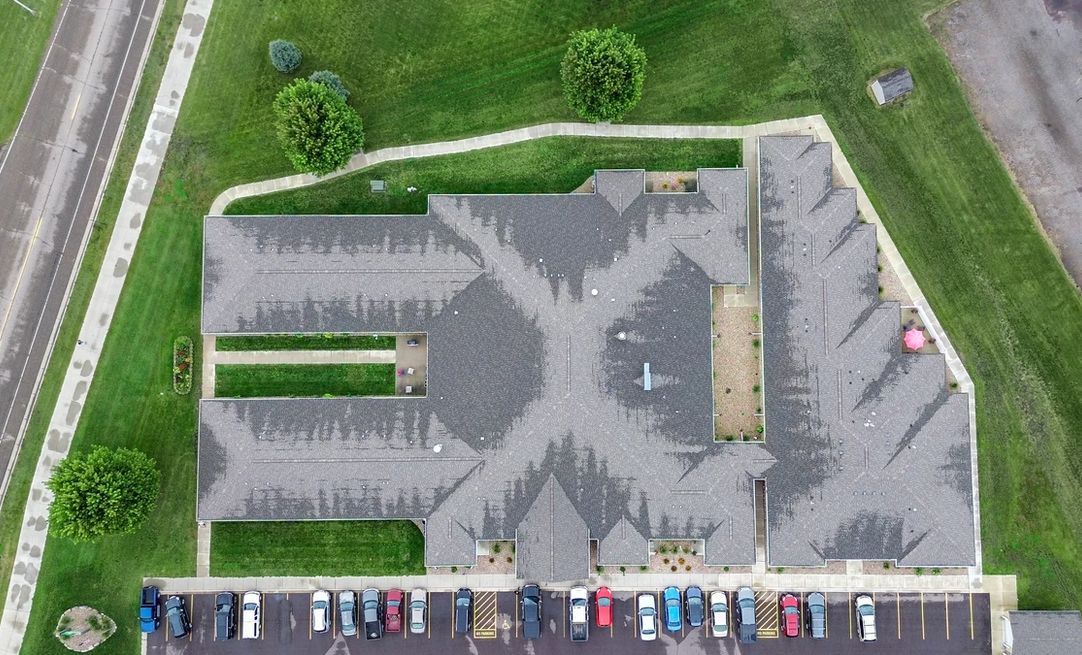 An aerial view of a building with a lot of cars parked in front of it.