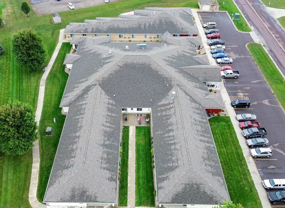 An aerial view of a large building with cars parked in front of it.