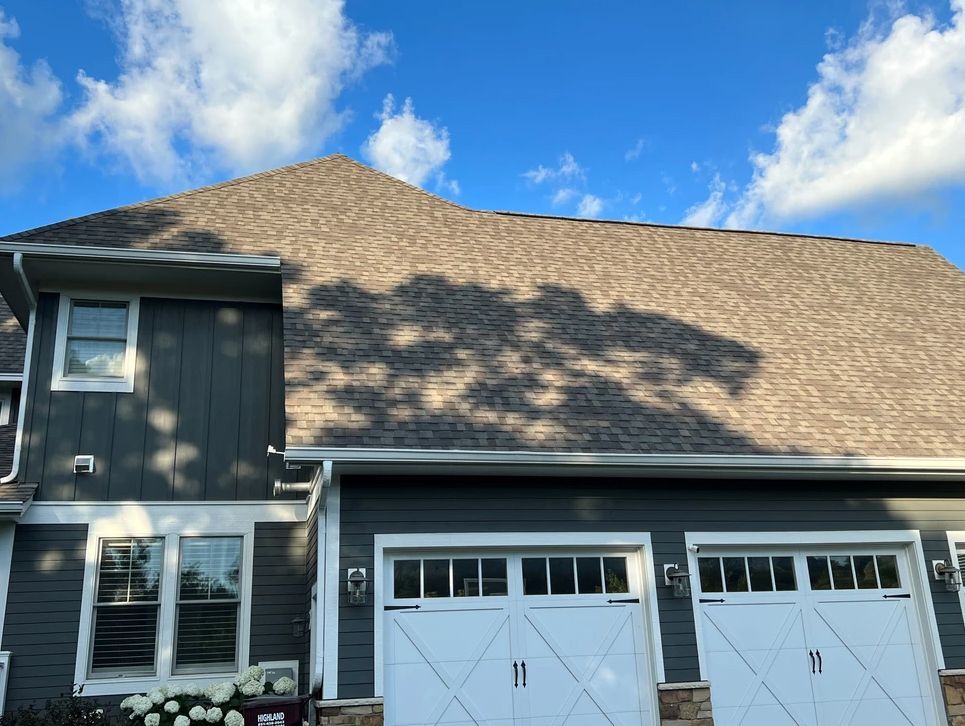 A house with two garage doors and a large roof.