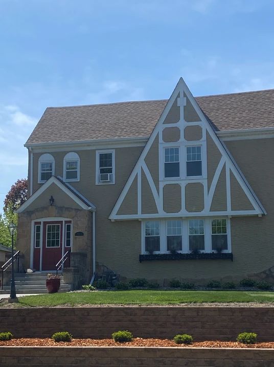 A house with a triangle shaped roof and a red door.