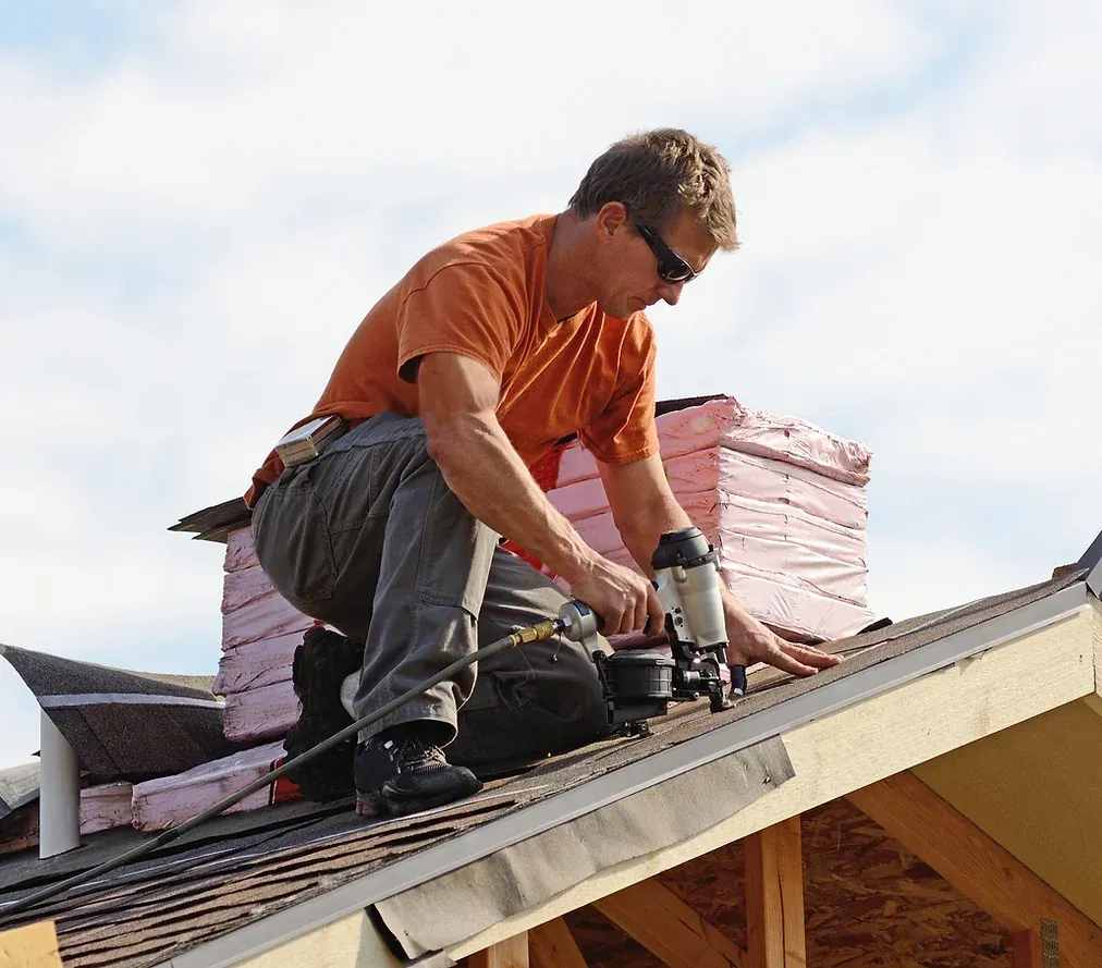 A man is working on the roof of a house.