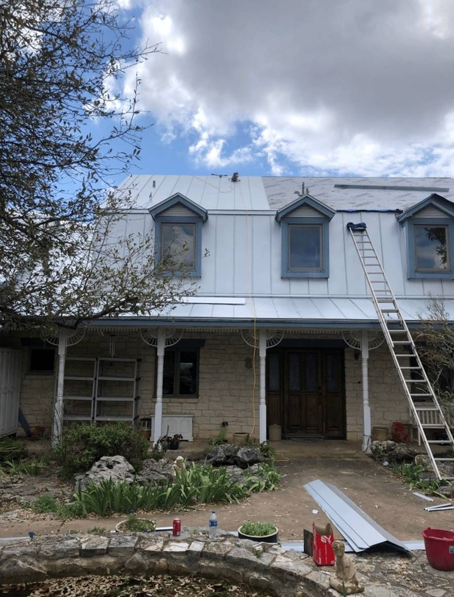 A house with a metal roof is being painted