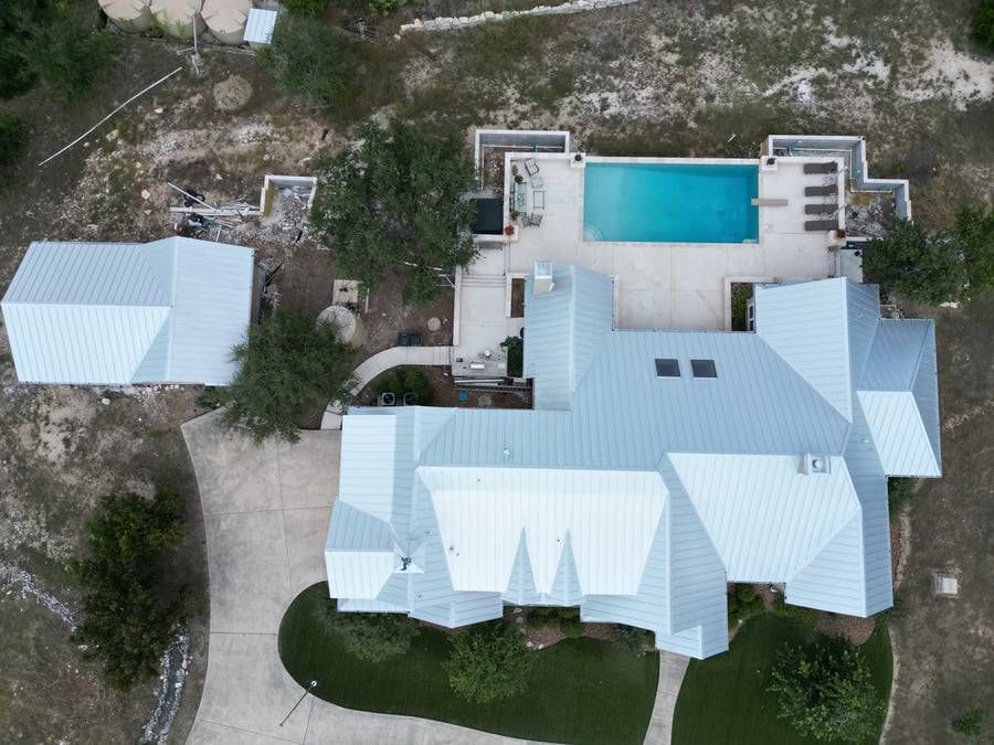 A white truck is parked in front of a large house