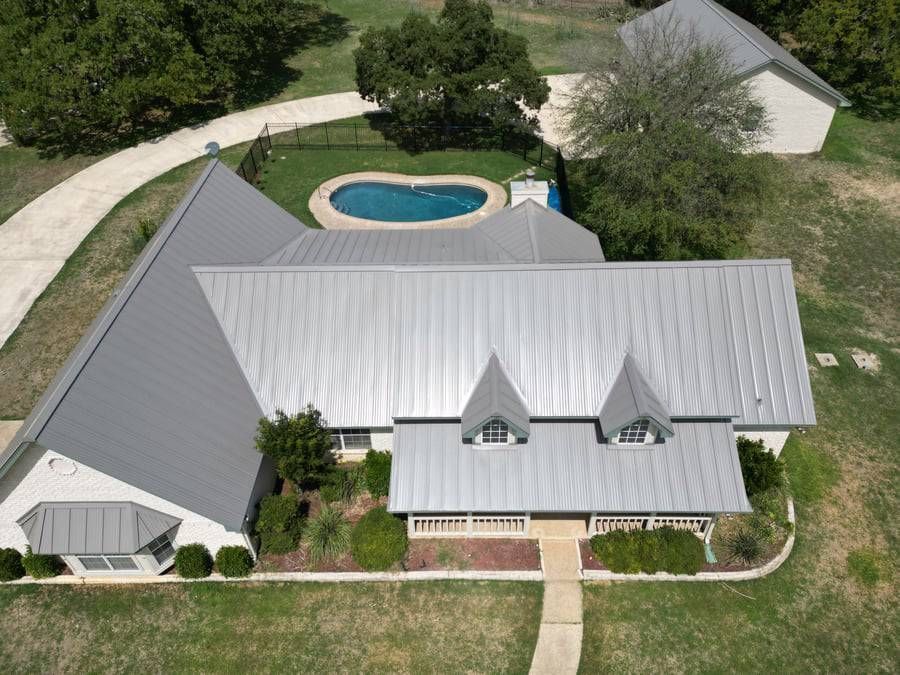 An aerial view of a house with a pool in the backyard