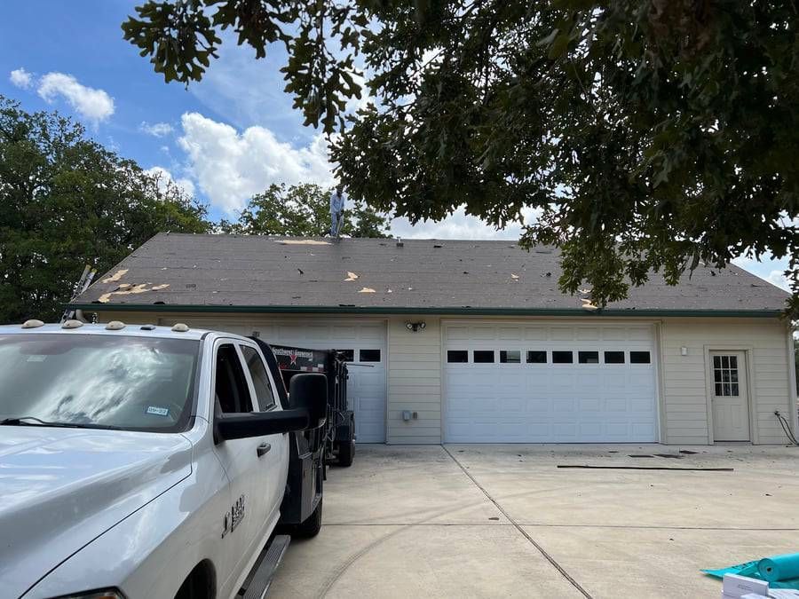 A white truck is parked in front of a garage door