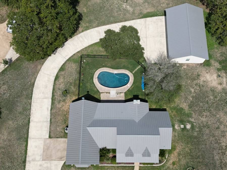 An aerial view of a house with a pool in the backyard
