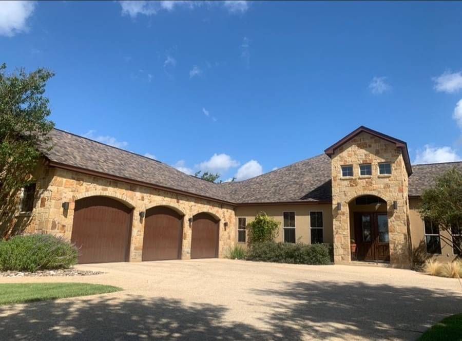 A large house with a lot of garages and a blue sky in the background