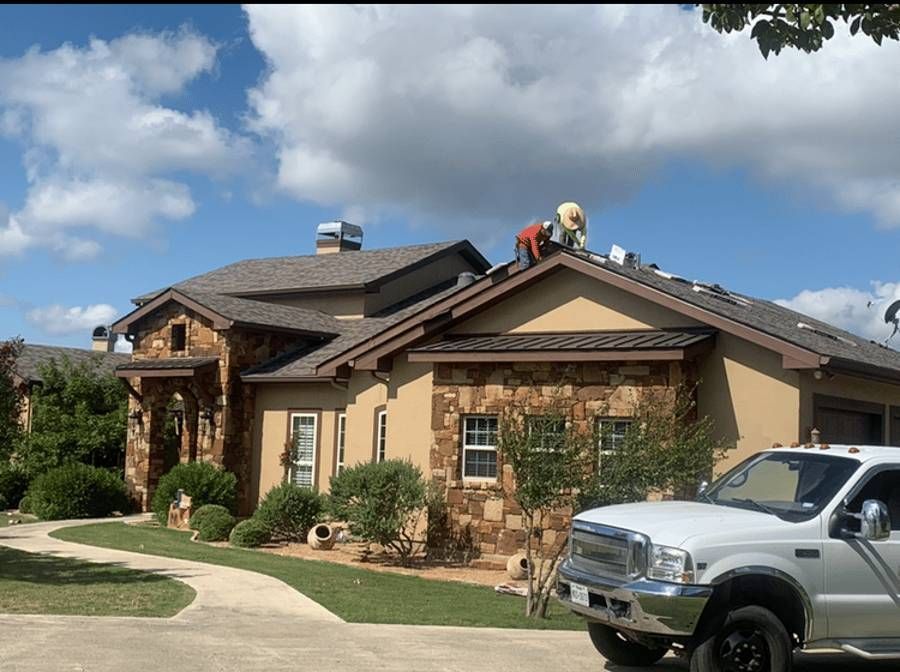 Two men are working on the roof of a house