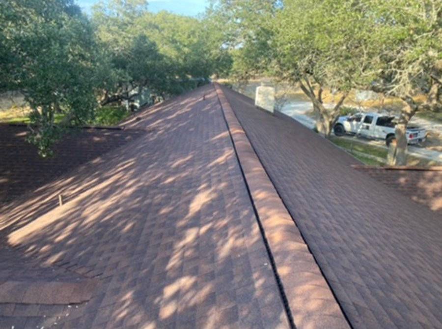 A roof with a lot of trees in the background and a truck parked on the side of it