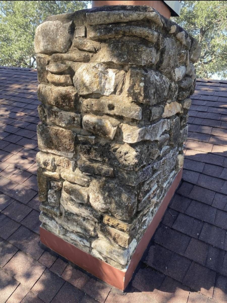A stone chimney sitting on top of a roof