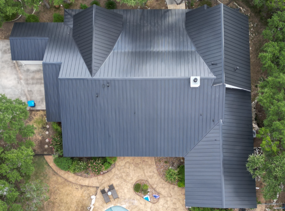 An aerial view of a house with a black metal roof
