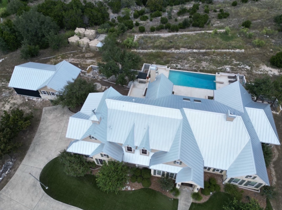 An aerial view of a large house with a metal roof
