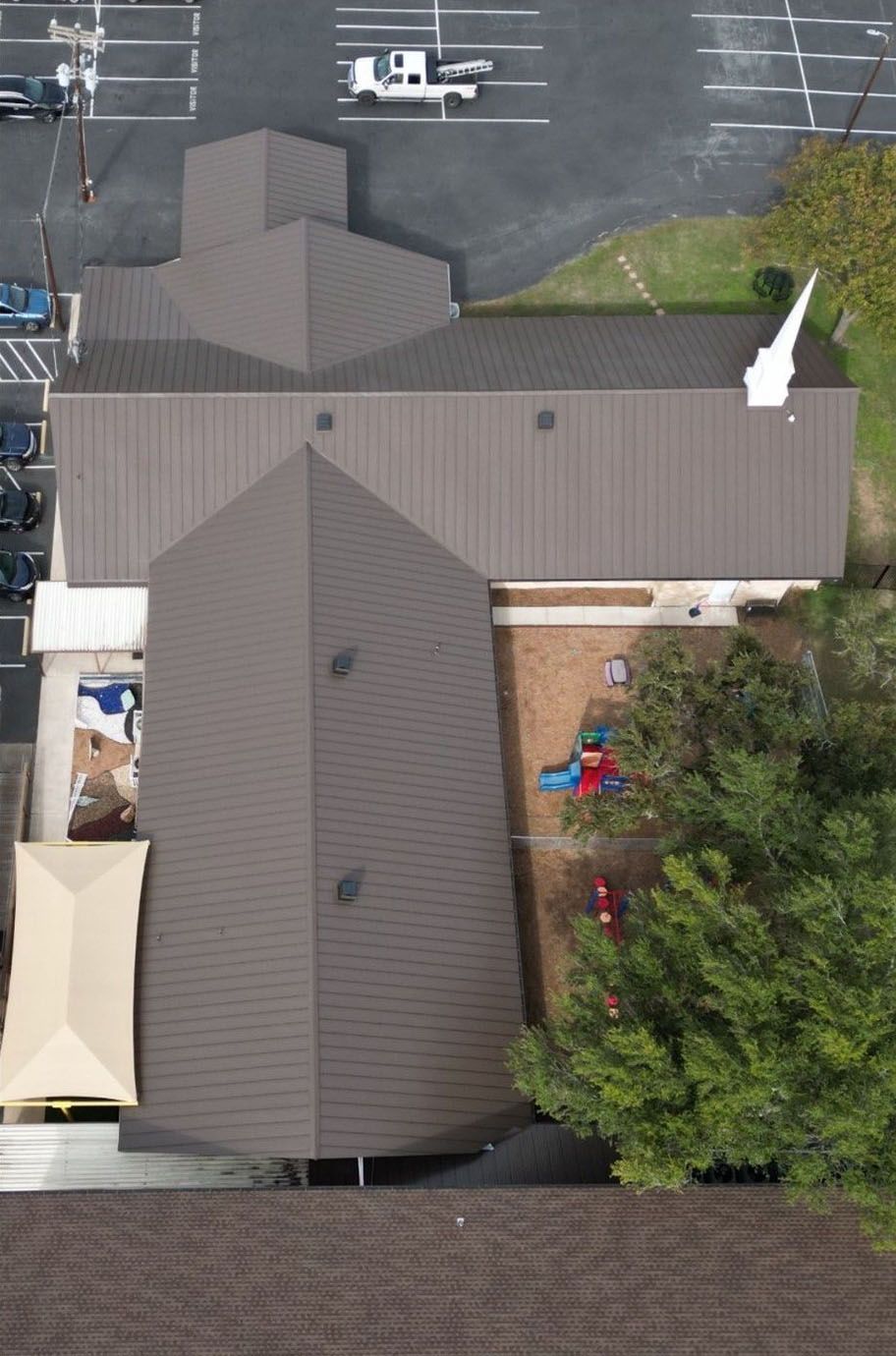 An aerial view of a church with a brown metal roof