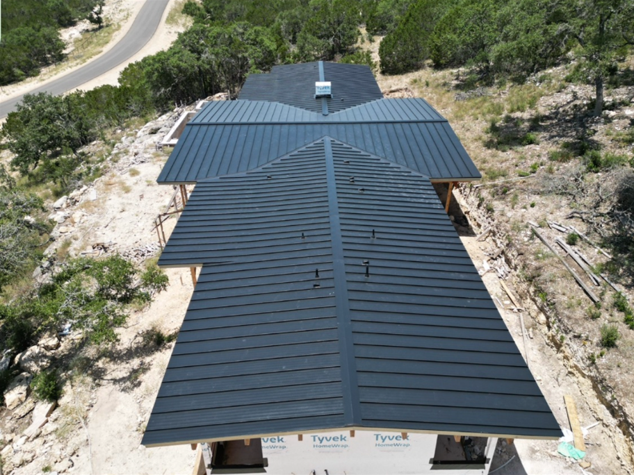 An aerial view of a house with a black metal roof