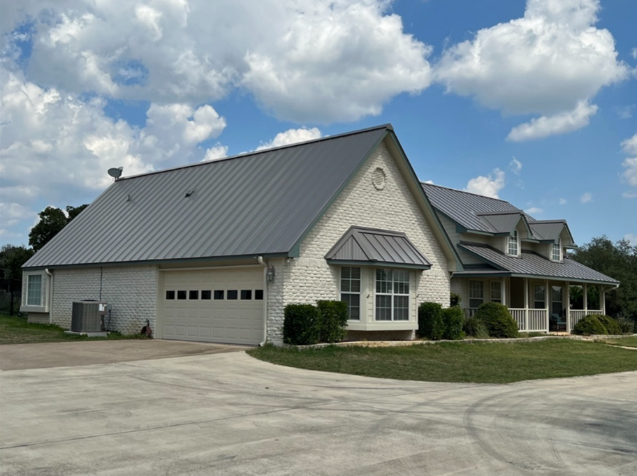 A large white house with a gray metal roof