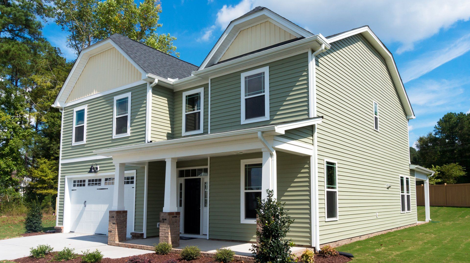 Learn More About Siding A large house with green siding and white trim