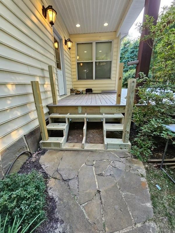 A wooden deck is being built on the side of a house.
