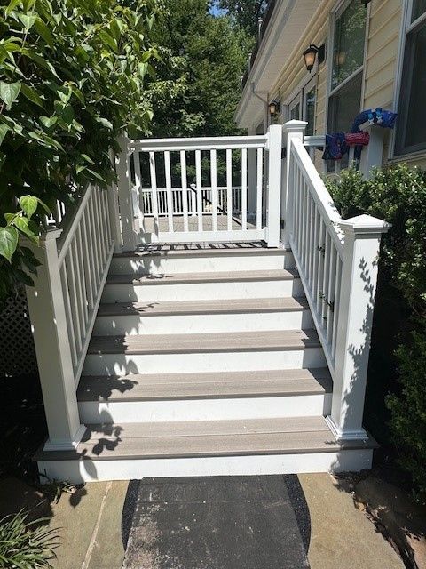 A set of stairs leading up to a house with a white railing