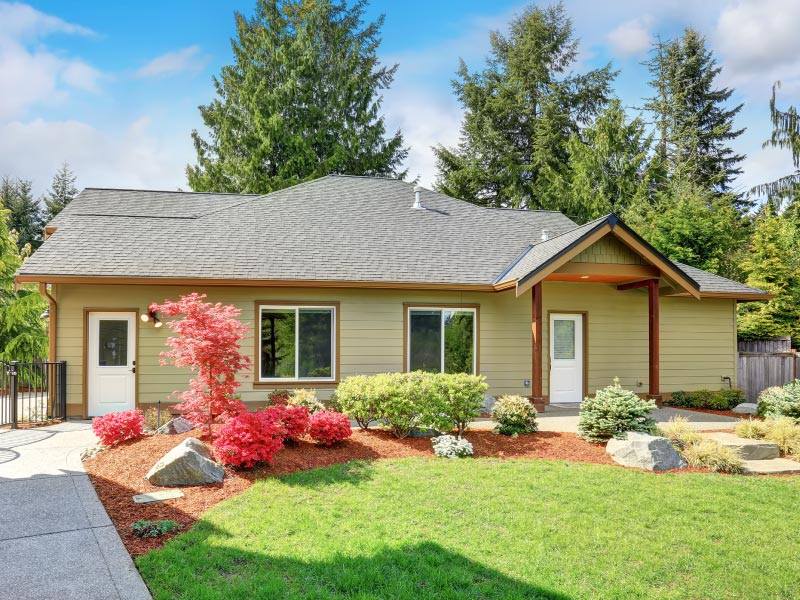 A house with a lush green lawn and trees in the background.