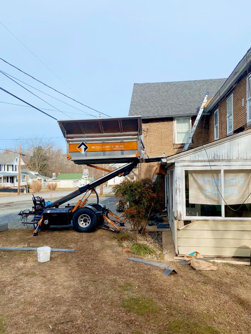 A truck is parked in front of a house with a trailer attached to it.
