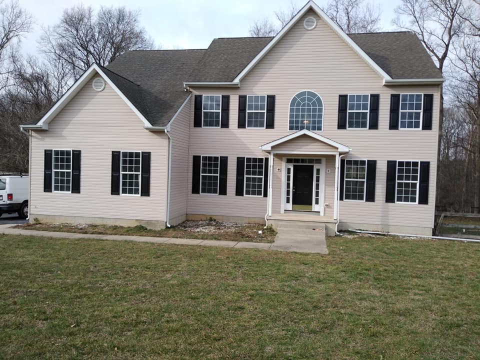 A large white house with black shutters on the windows