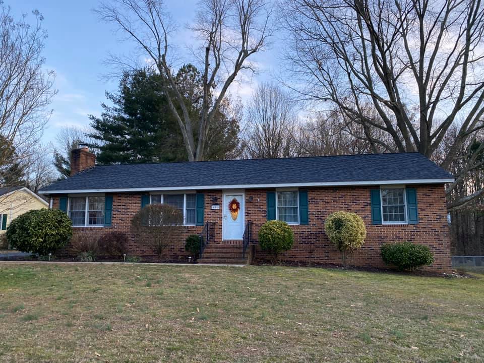 A brick house with a blue roof and blue shutters