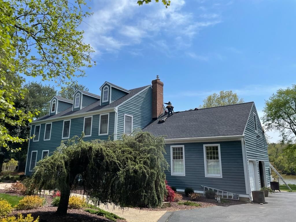 A man is working on the roof of a house.