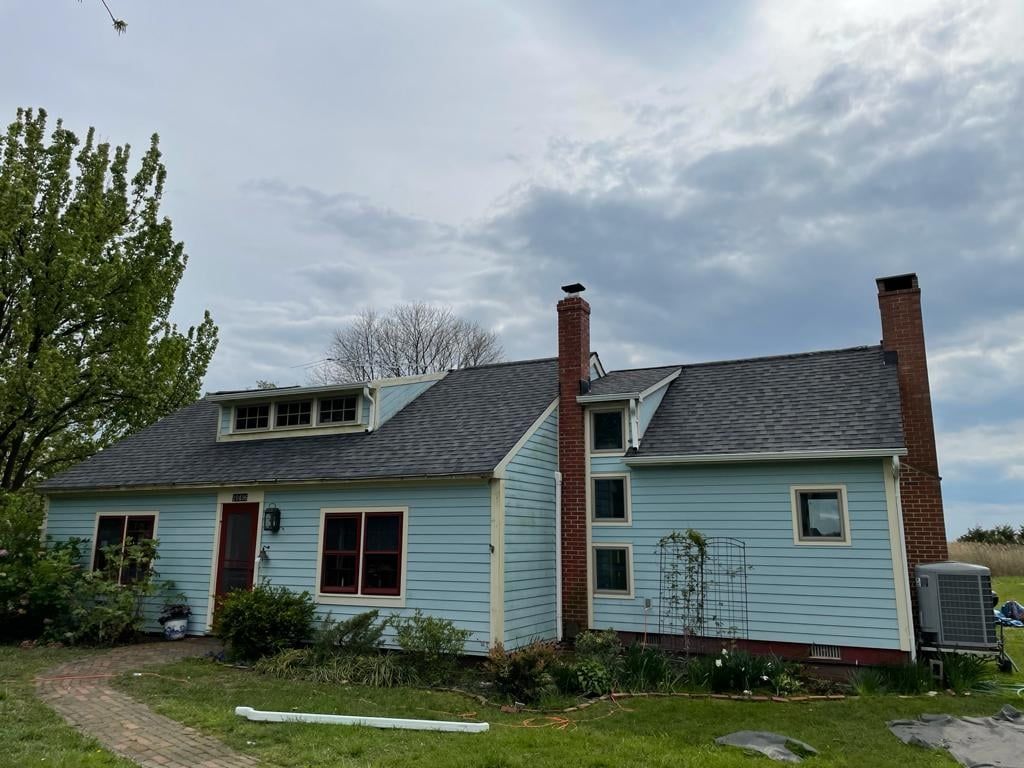 A blue house with a gray roof and a chimney