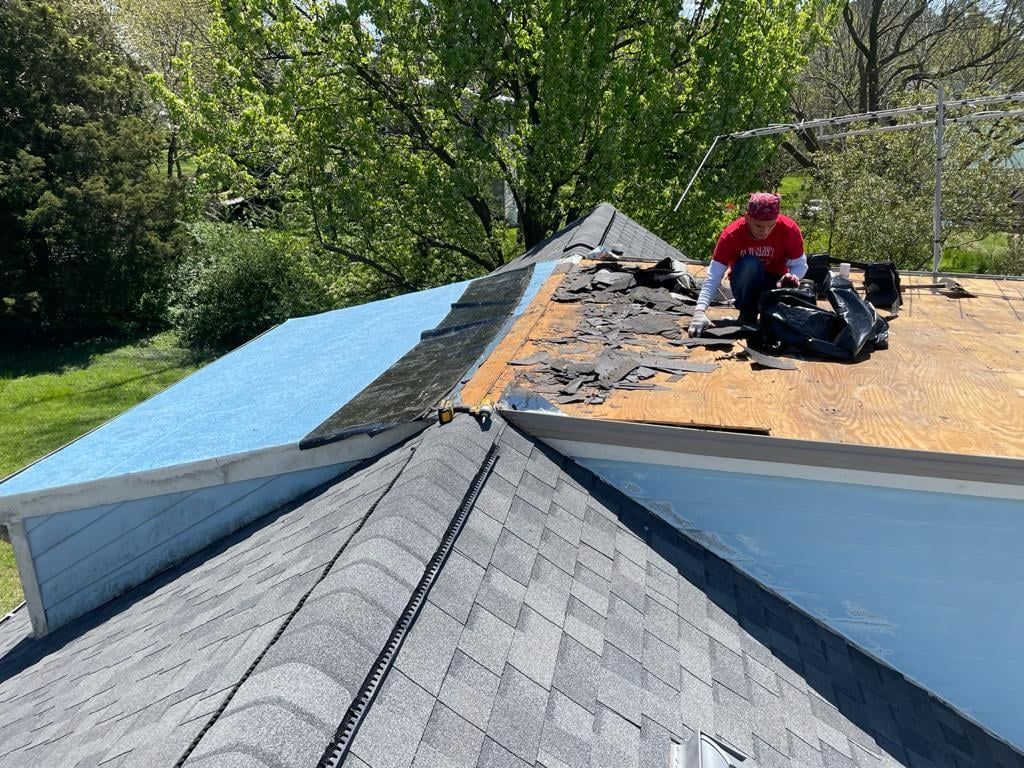 A man is working on the roof of a house.