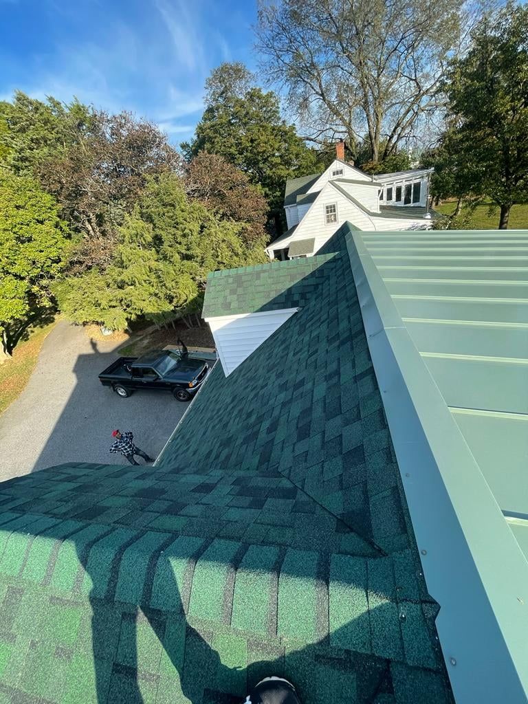 A black car is parked on the roof of a house.