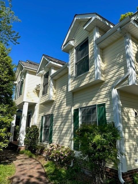A large white house with green shutters on the windows
