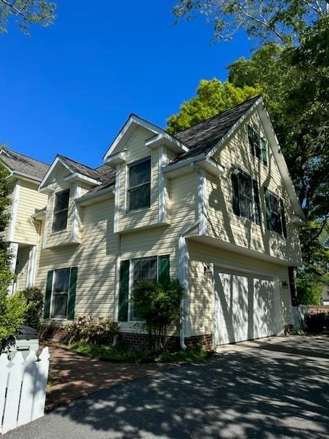 A white house with green shutters and a garage