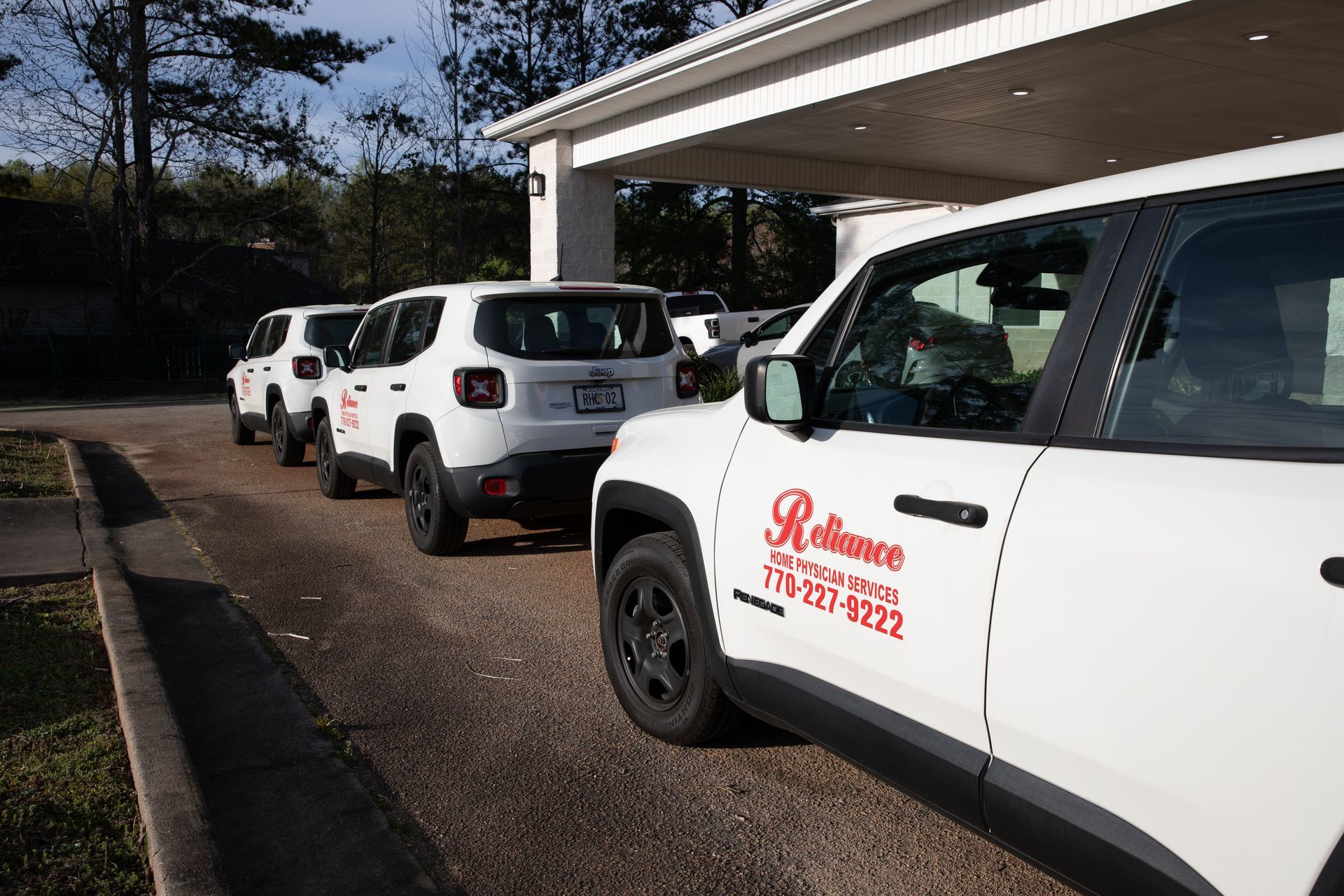 A row of white cars are parked in front of a building.