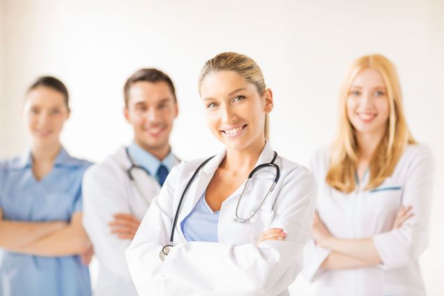 A group of doctors and nurses are posing for a picture.