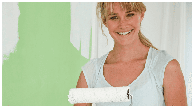 Smiling woman holding a roller paint