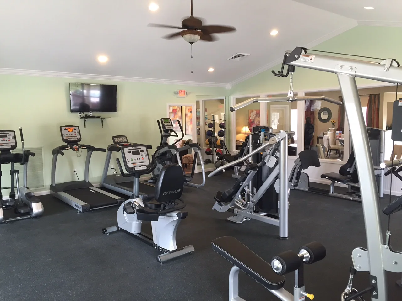 Gym with treadmills, weights, and other exercise machines in a bright room.