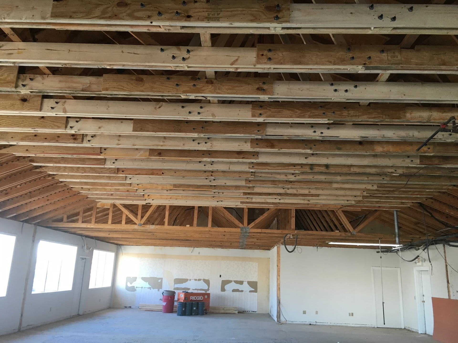 Interior view of a room with exposed ceiling beams and unfinished walls.